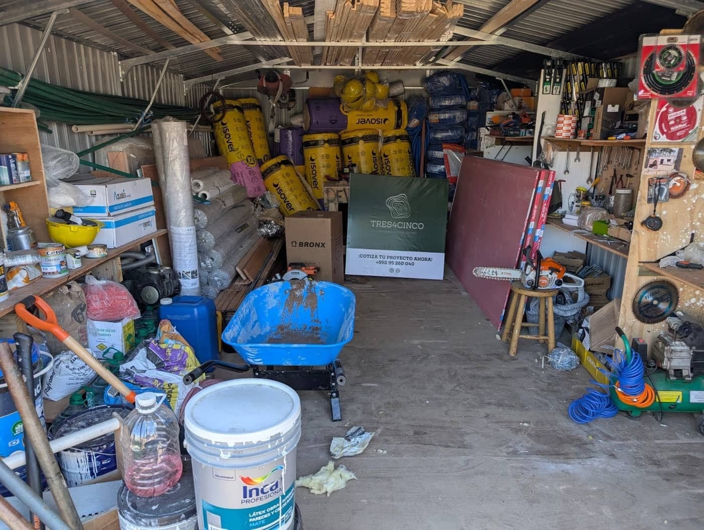 The TRES4CINCO store: Isover insulation rolls, timber, tools and the company sign.