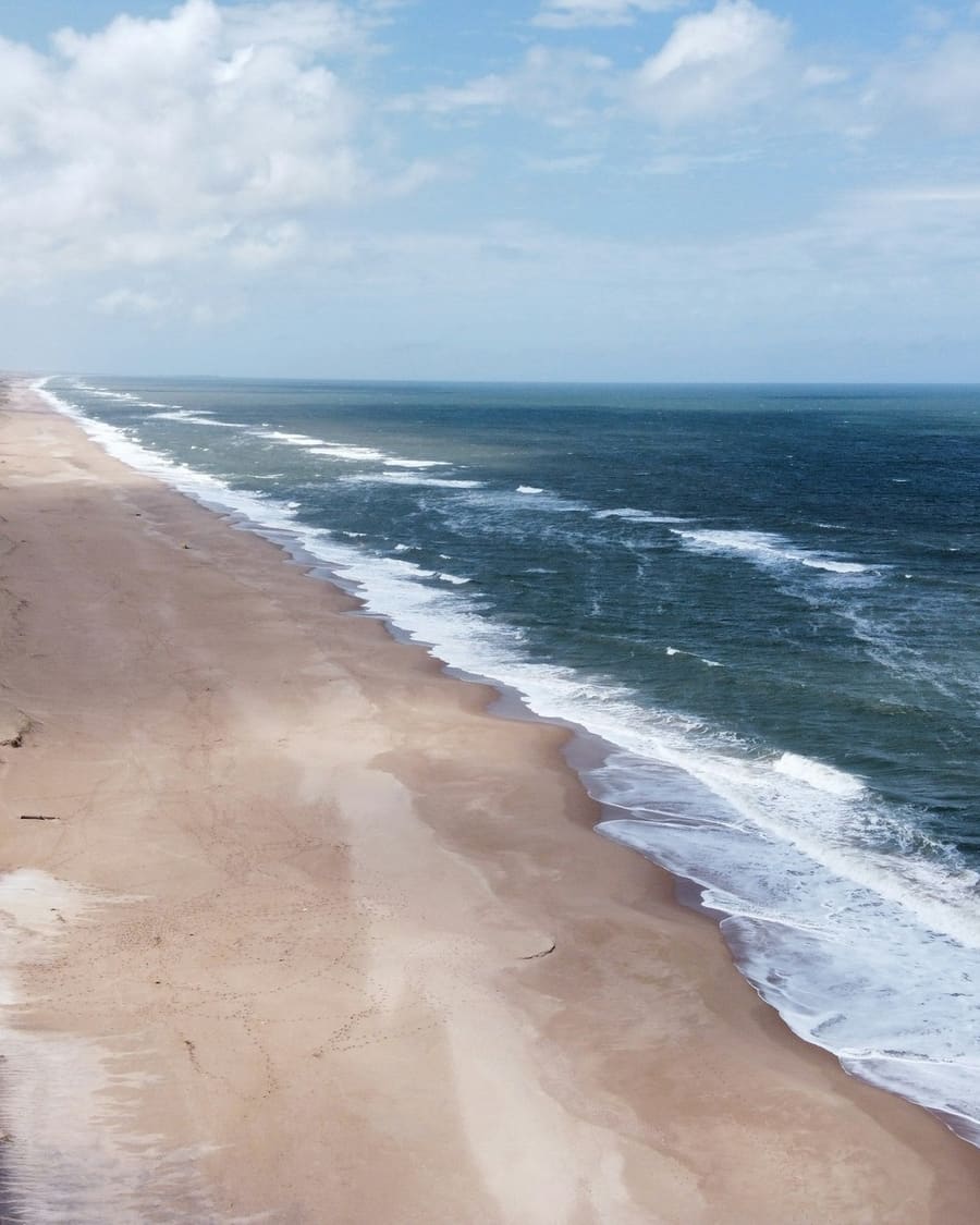 Long, empty beach near Cabo Polonio from the air, with surf