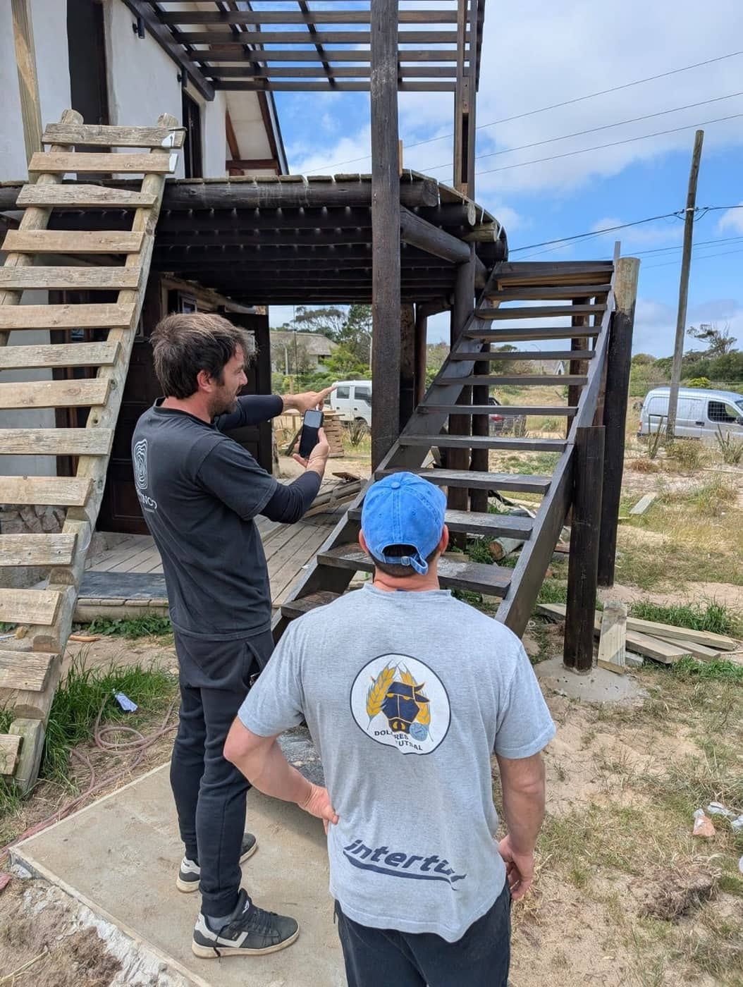 Ramiro on site, phone in hand, pointing at the new staircase.