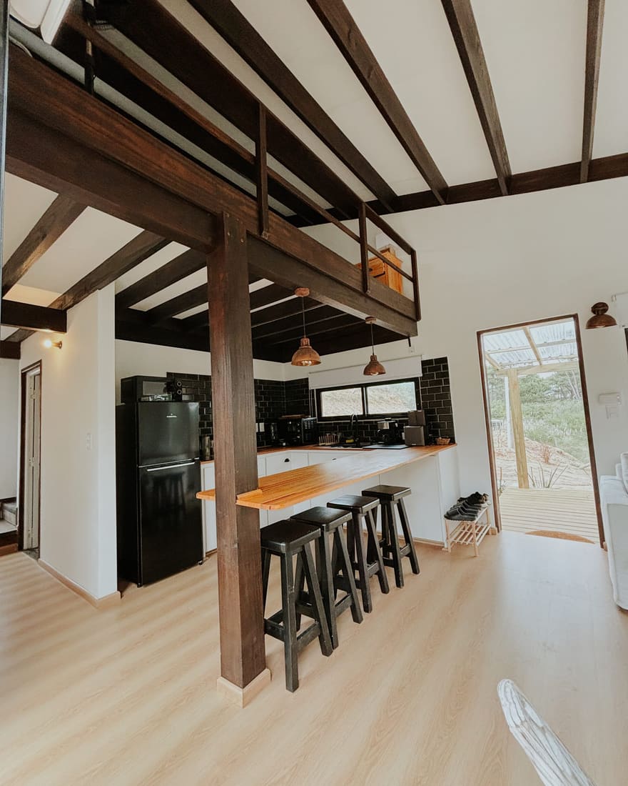 Finished living space with an open kitchen, timber beams and a mezzanine.