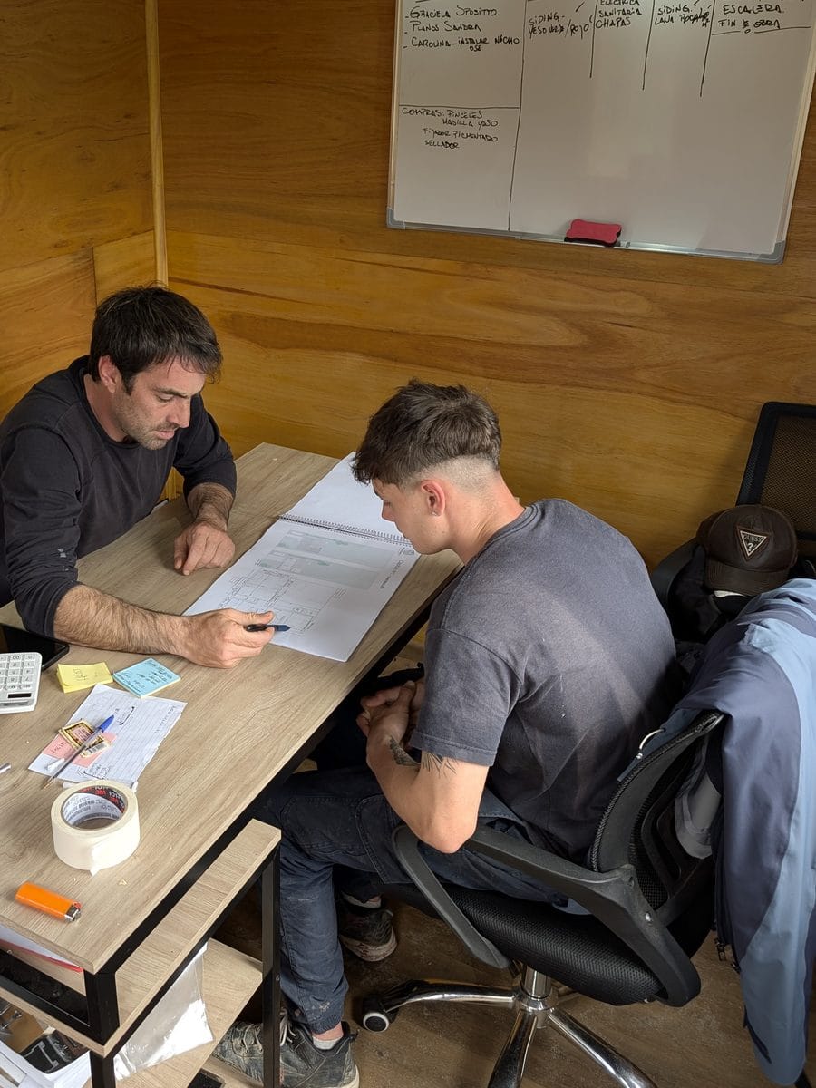 Ramiro and a team member go over a plan together in the wood-lined office.