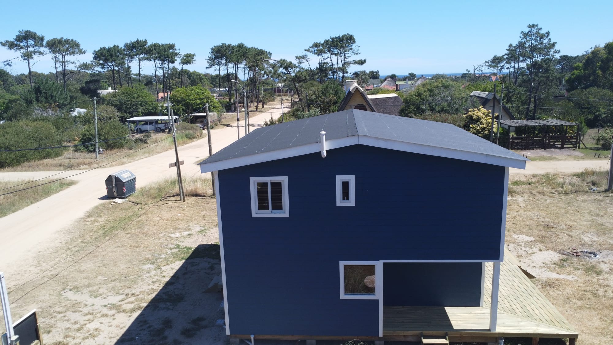 Casa Azul from the air: two facades, the neighbourhood and the sea on the horizon.