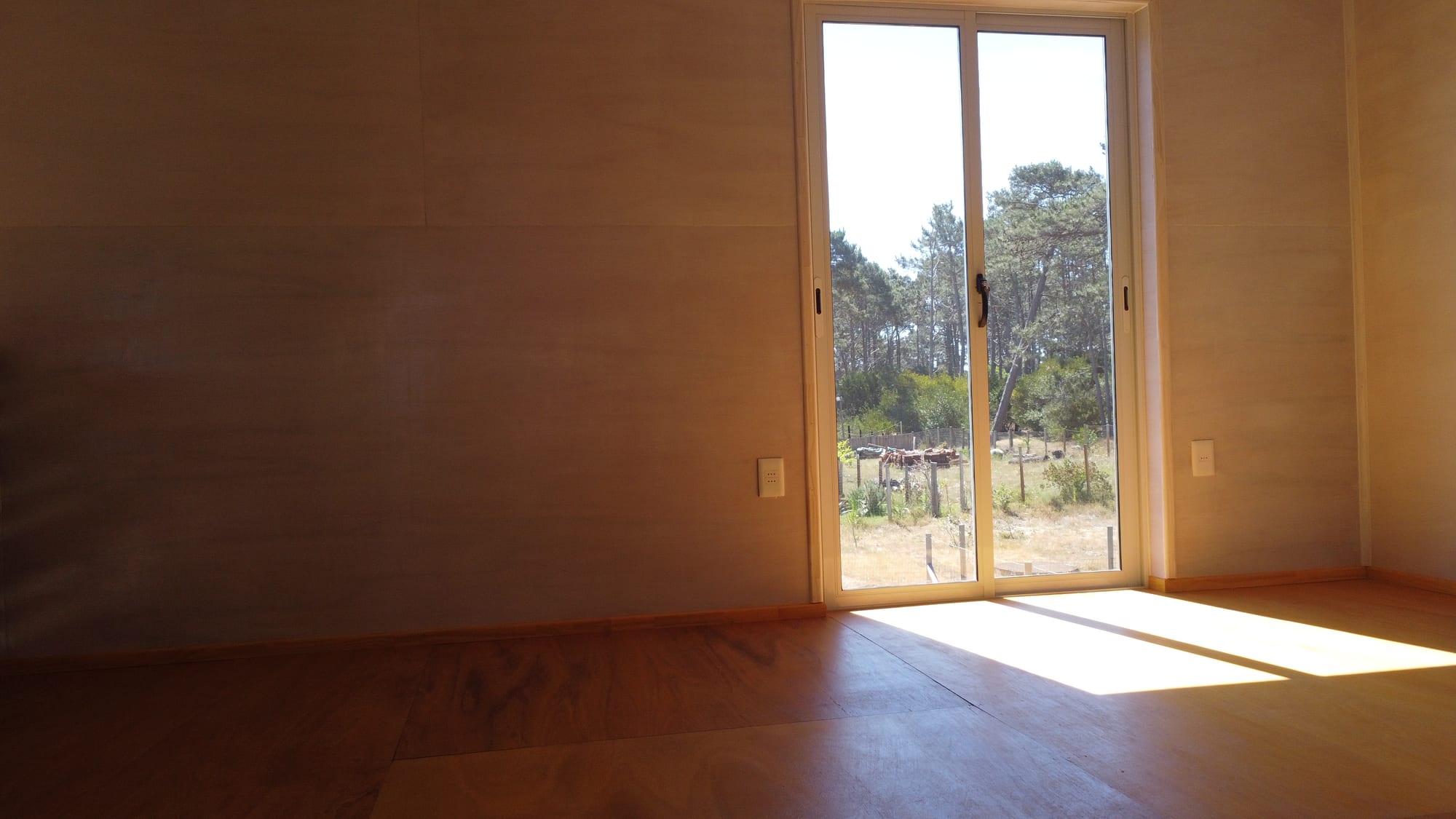 Living area of Casa Azul with warm sunlight on the timber floor.