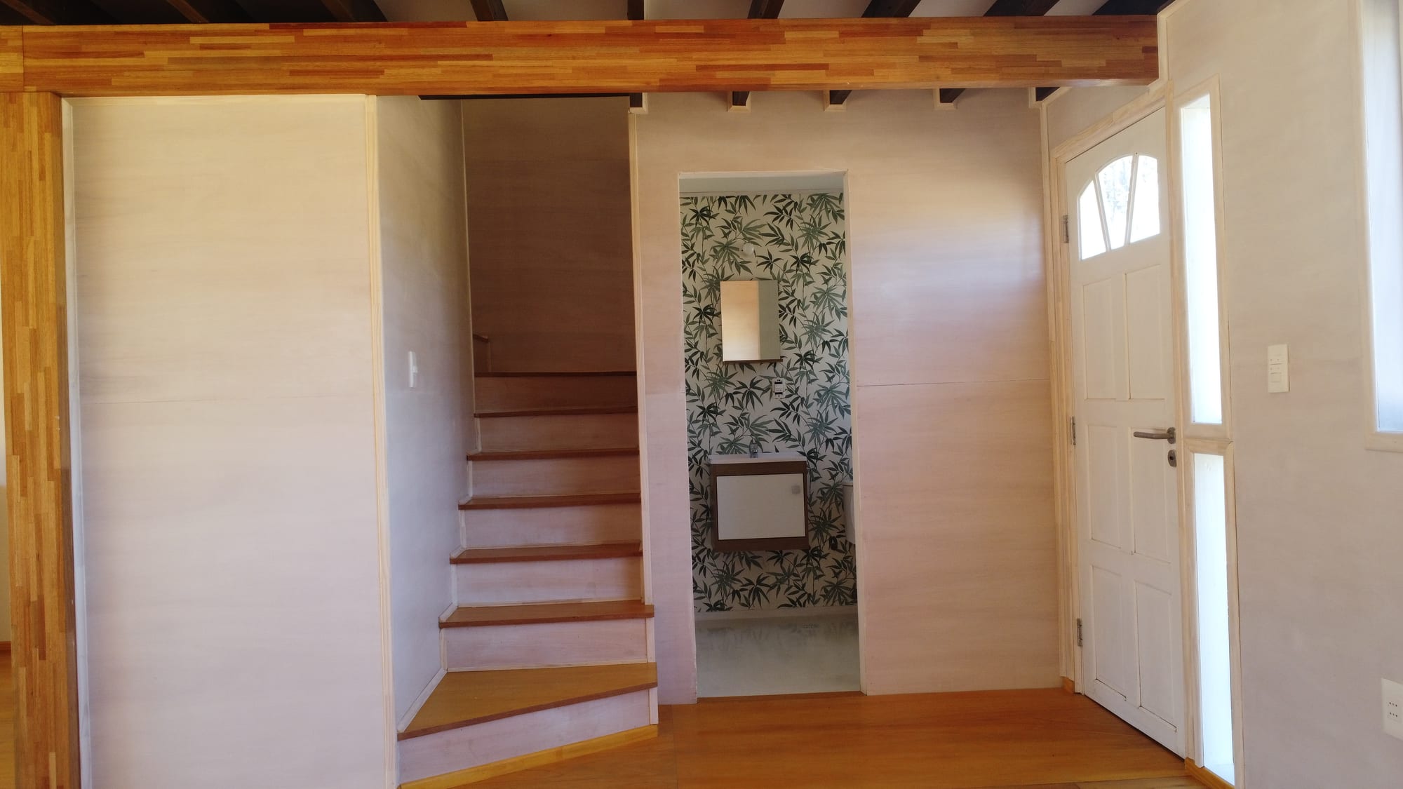 Open living area of Casa Azul with a panoramic window and a view of the pine forest.