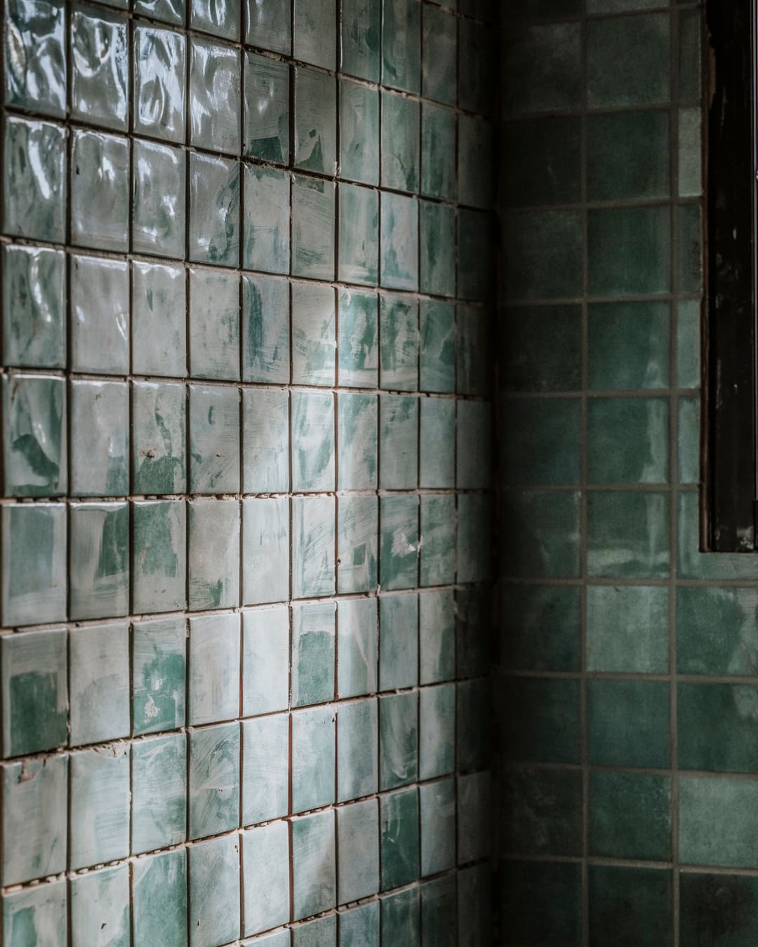 Green glazed wall tiles, close up.